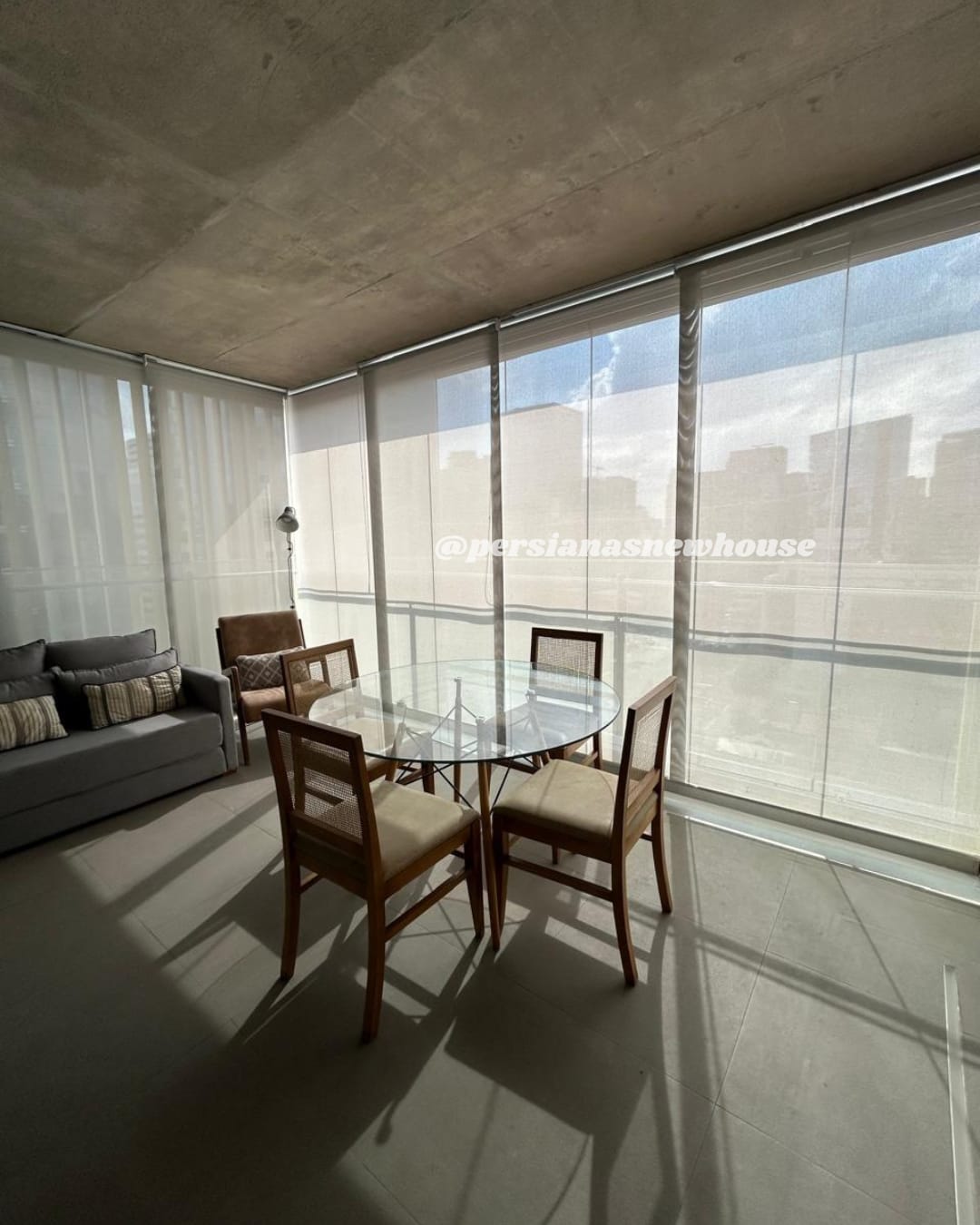 Sala de jantar envidraçada com cortina rolô em tela solar